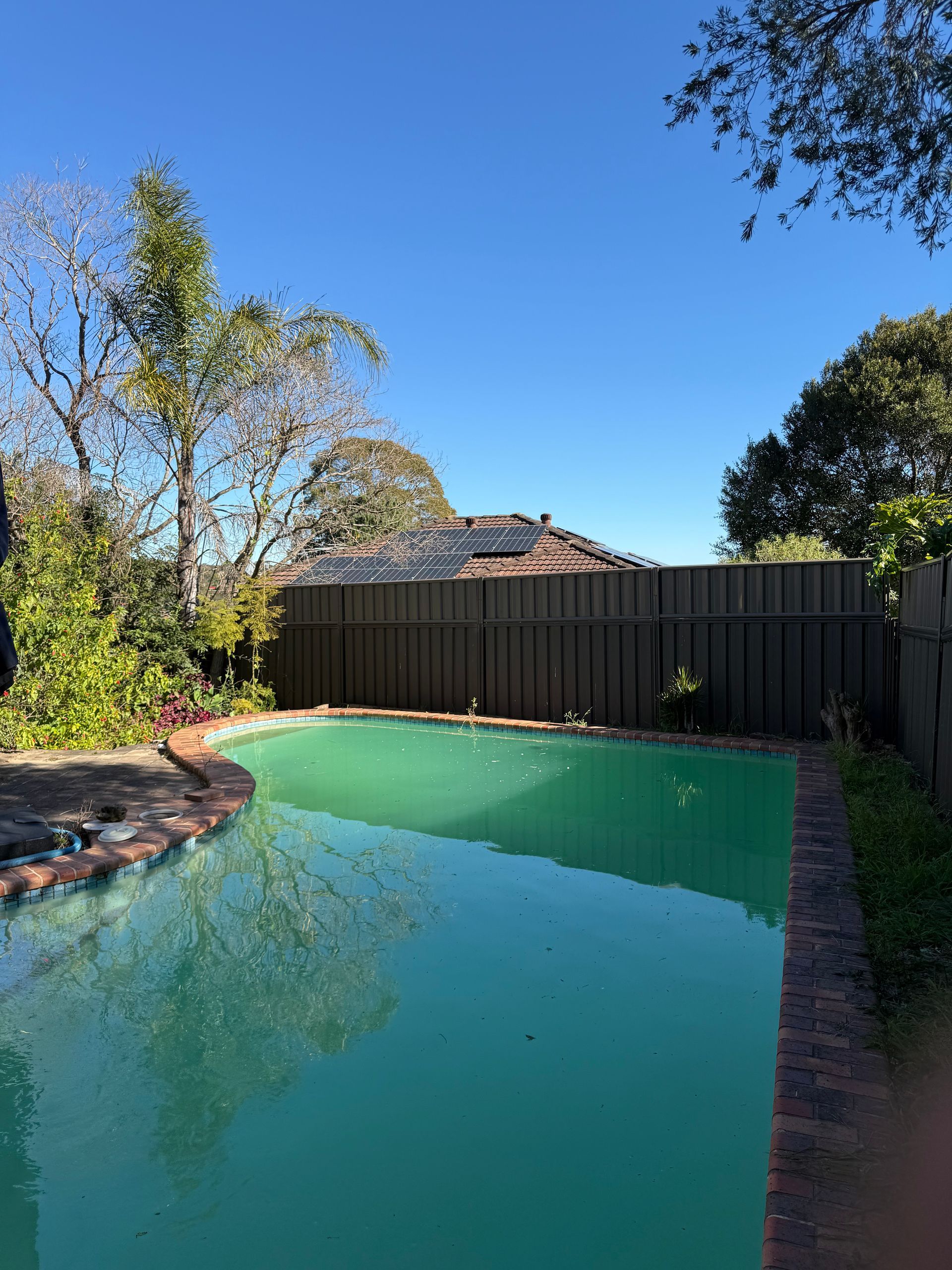A Large Swimming Pool with A Fence Around It — JOA - Construction & Maintenance Pty Ltd in Appin, NSW