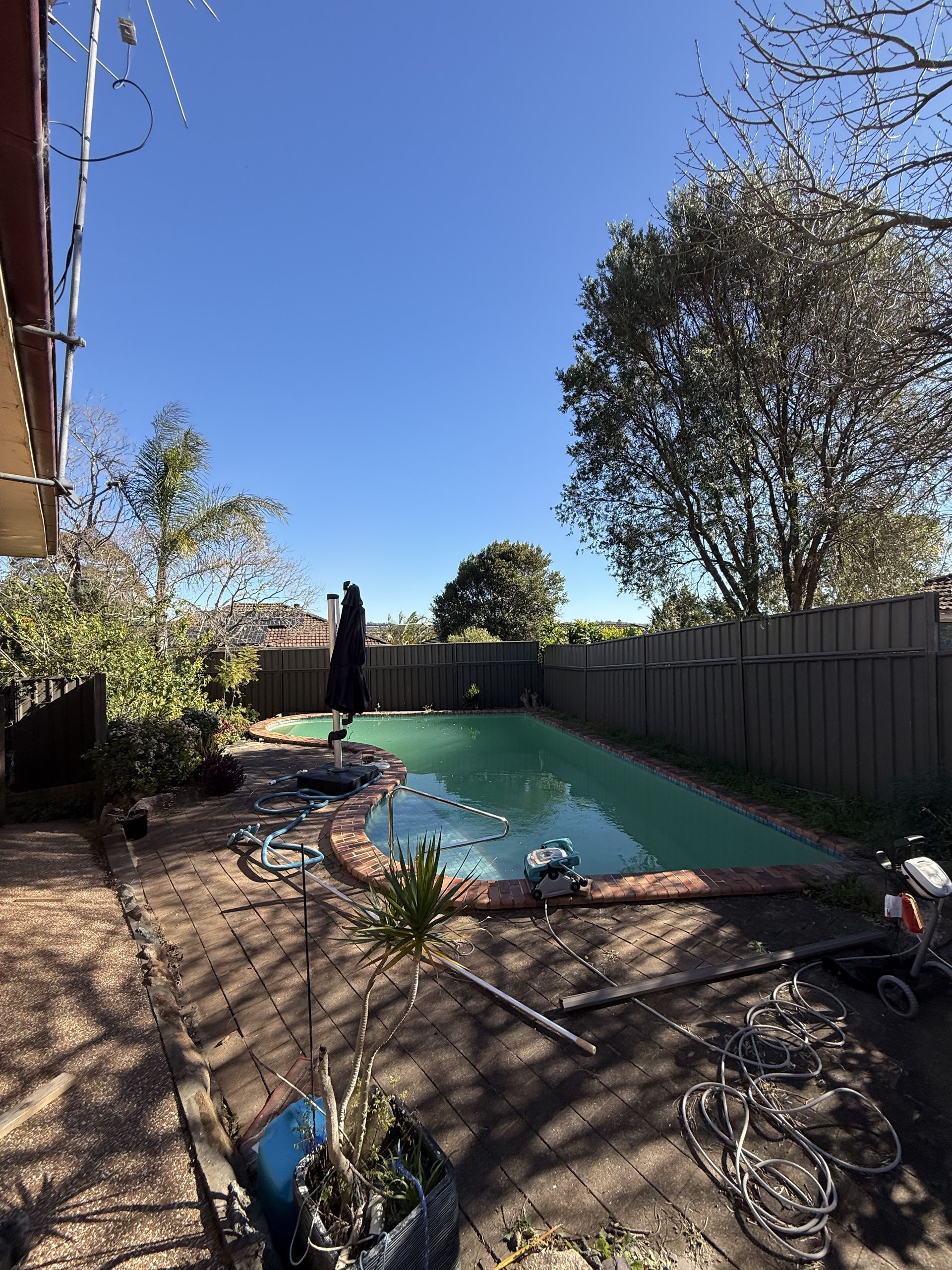 There is a large swimming pool in the backyard of a house. — JOA - Construction & Maintenance Pty Ltd in Campbelltown, NSW