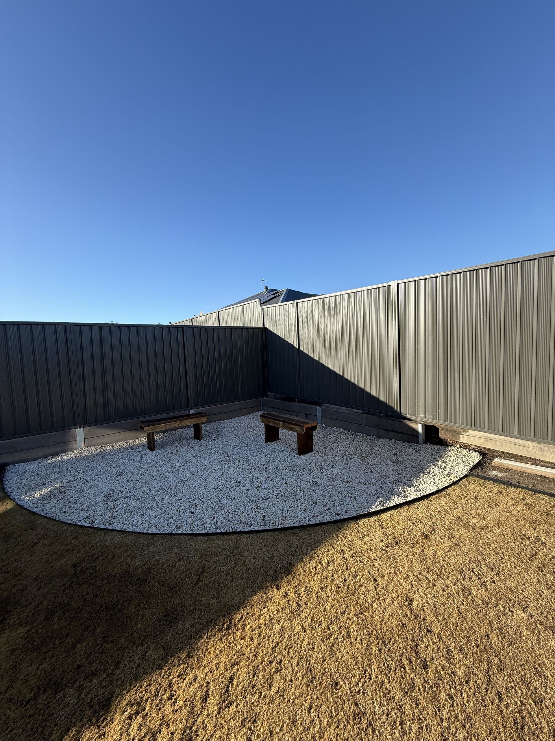 There Is a Fence in The Background and A Circle of Gravel in The Middle of The Yard. — JOA - Construction & Maintenance Pty Ltd in Campbelltown, NSW