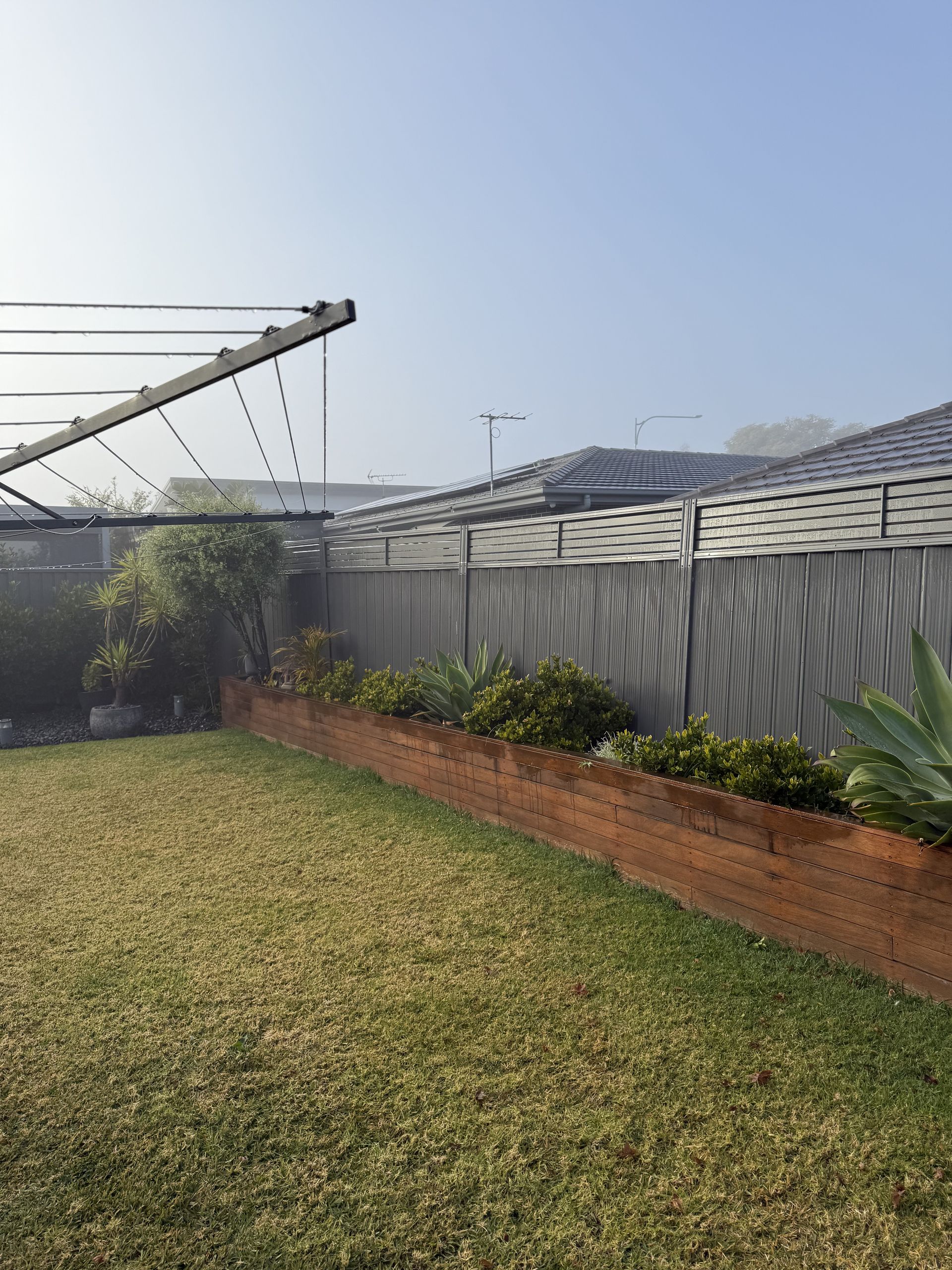 A Lawn with A Clothes Line and A Fence in The Background. — JOA - Construction & Maintenance Pty Ltd in Appin, NSW