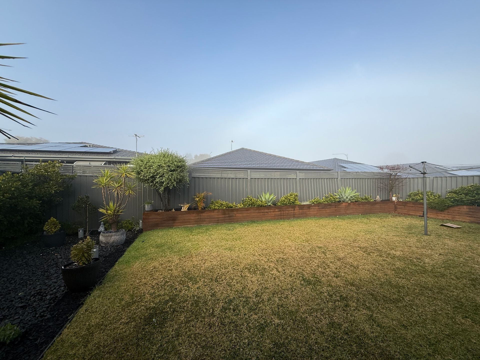 A Backyard with A Fence and A Lot of Grass — JOA - Construction & Maintenance Pty Ltd in Campbelltown, NSW