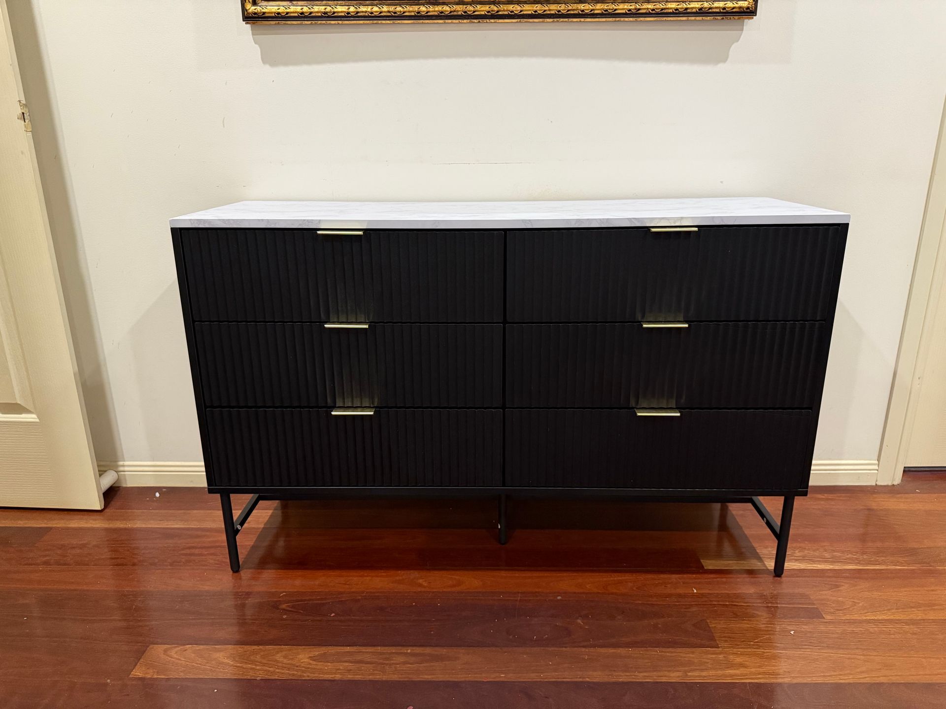 A Black Dresser with A White Top Is Sitting on A Wooden Floor. — JOA - Construction & Maintenance Pty Ltd in Appin, NSW