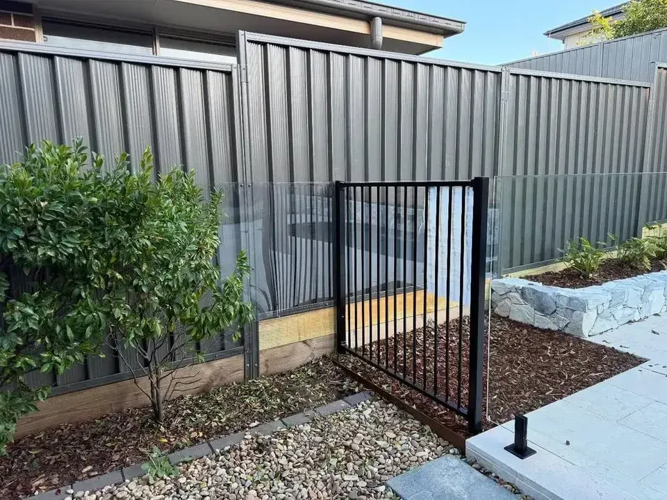 A Black Fence with A Gate in The Backyard of A House. — JOA - Construction & Maintenance Pty Ltd in Appin, NSW