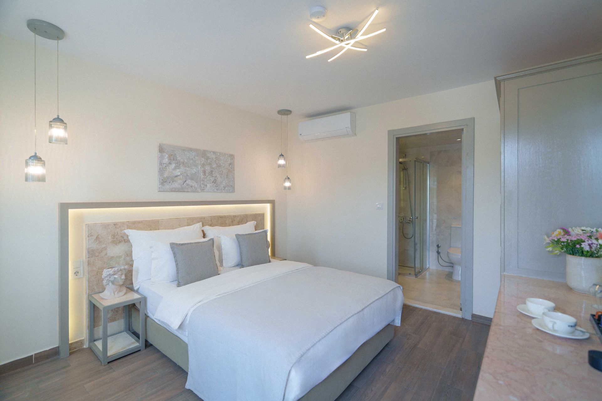 Elemanta Boutique Hotel | Bright modern bedroom with a large bed, bedside lamp, wall art