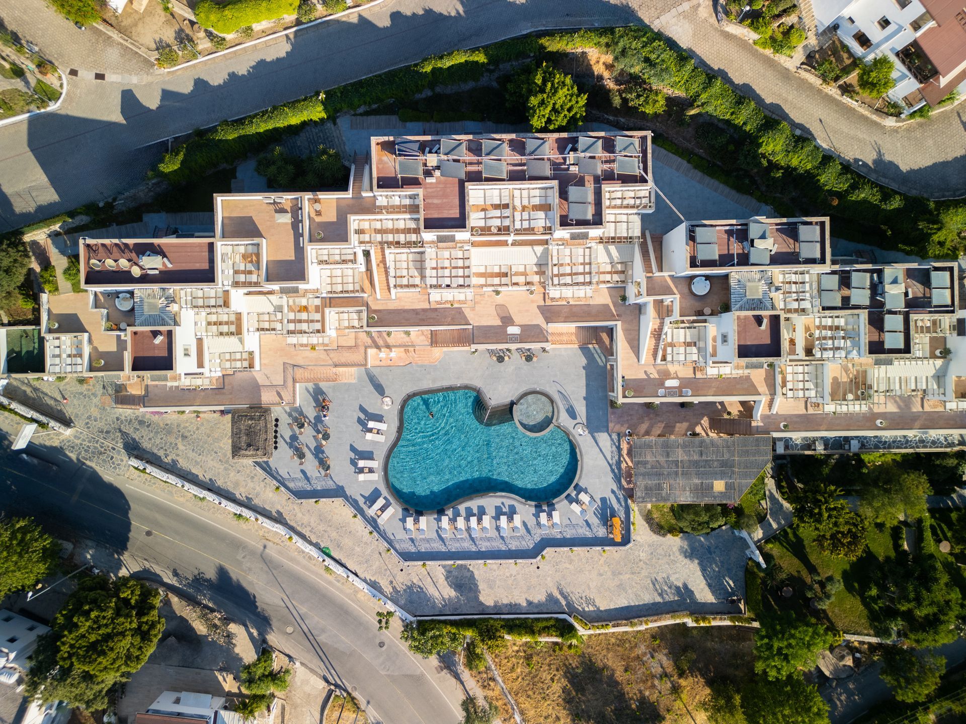  Elemanta Boutique Hotel | Aerial view of a resort complex with a large turquoise pool surrounded by buildings and roads