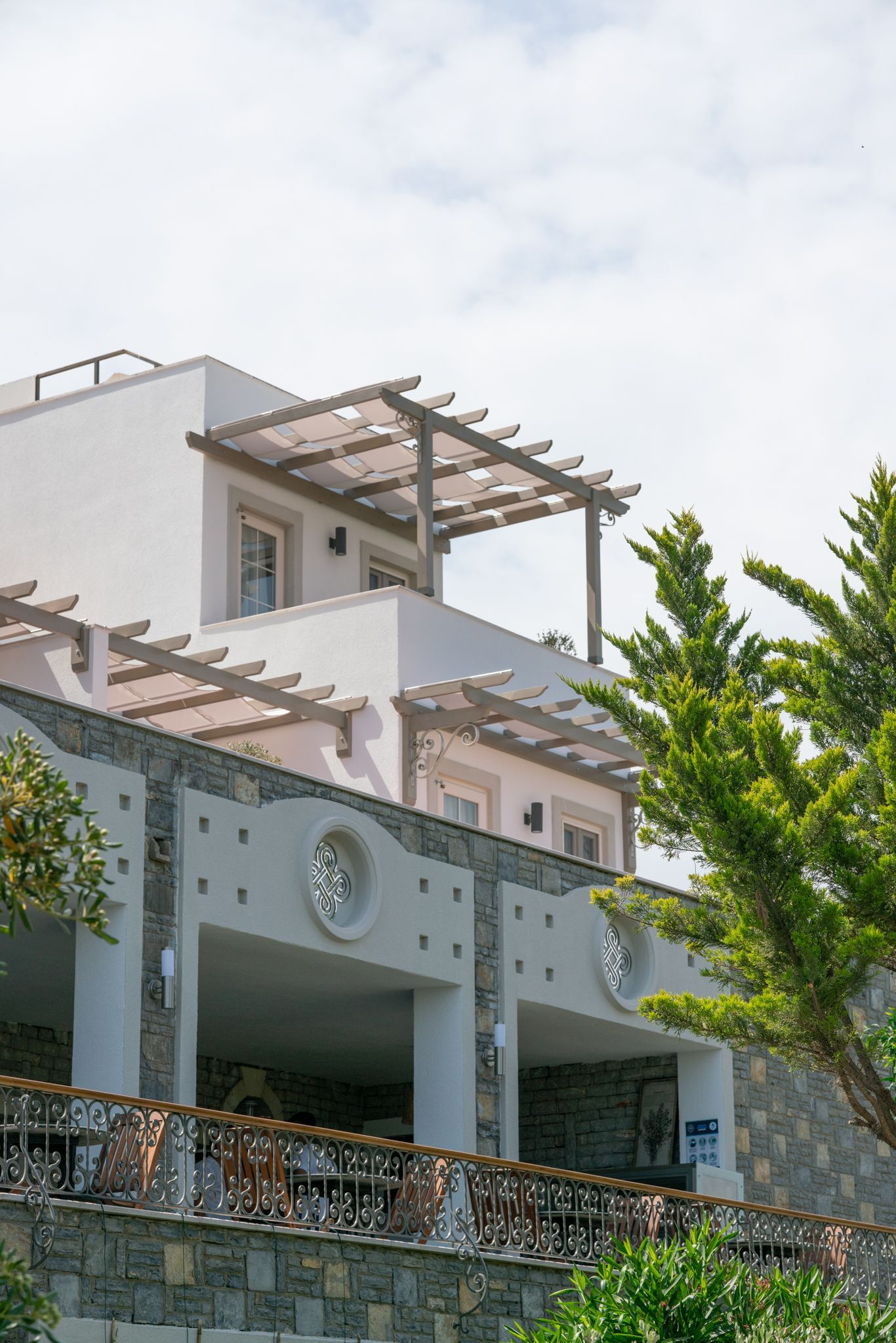 Elemanta Boutique Hotel | Modern white hillside house with balcony and pergola