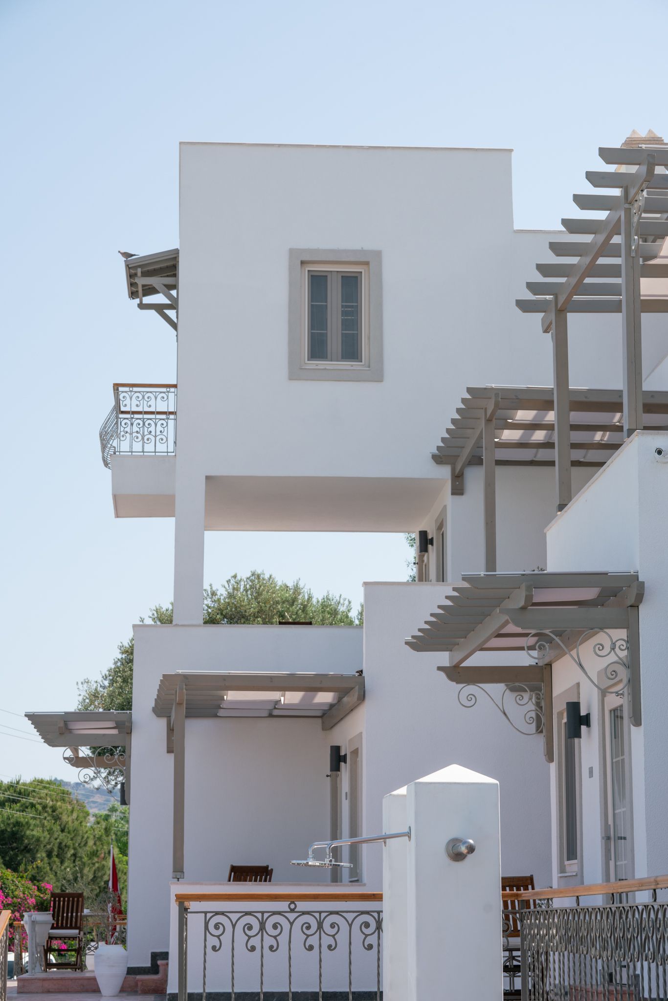  Elemanta Boutique Hotel |  White stucco Mediterranean-style building with balconies and pergolas against