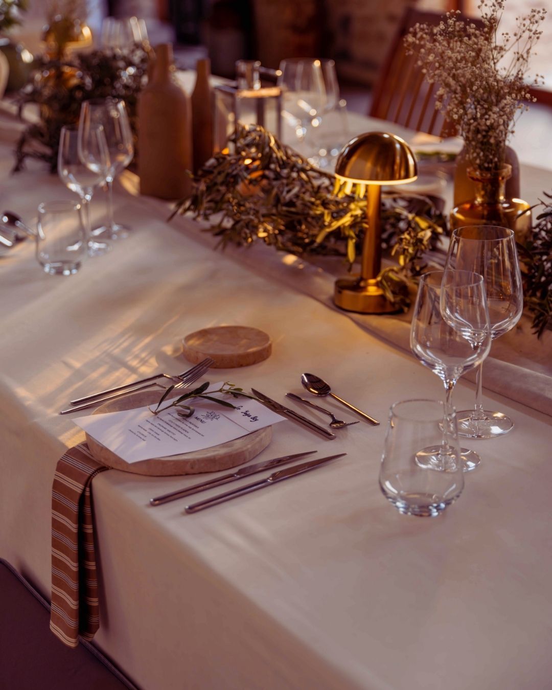 Elemanta Boutique Hotel | Elegant table setting with white linens, gold accents, glassware, and floral centerpiece