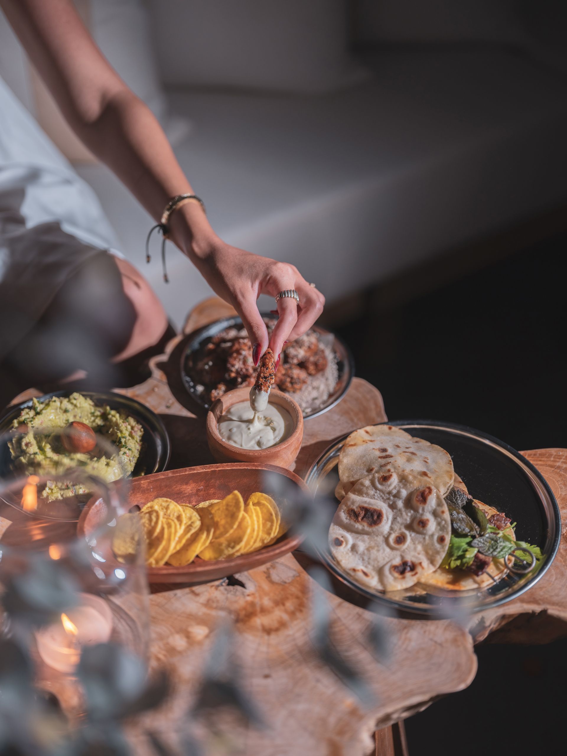 Elemanta Boutique Hotel | Hands serving assorted desserts on a rustic table with cookies, chips, and dips