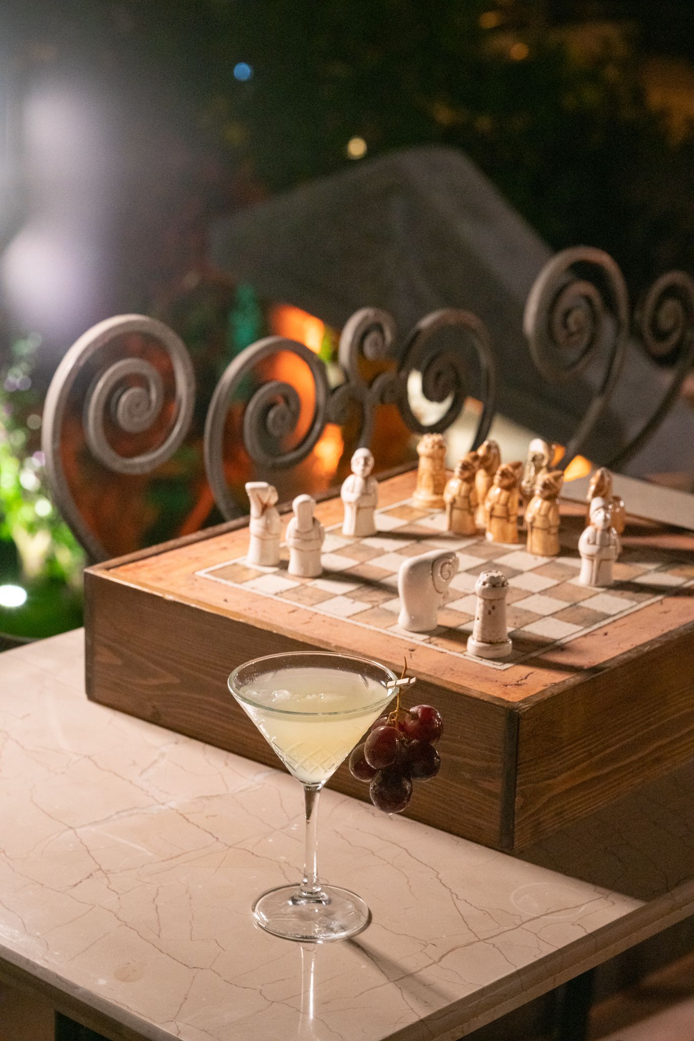  Elemanta Boutique Hotel |  Chessboard on a wooden table with pieces set up, beside a cocktail glass