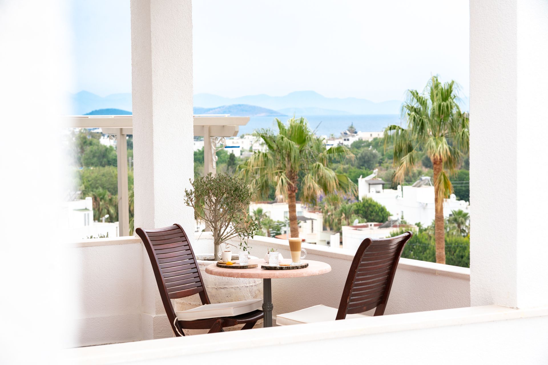  Elemanta Boutique Hotel | Balcony with two chairs and a table overlooking palm trees and the sea