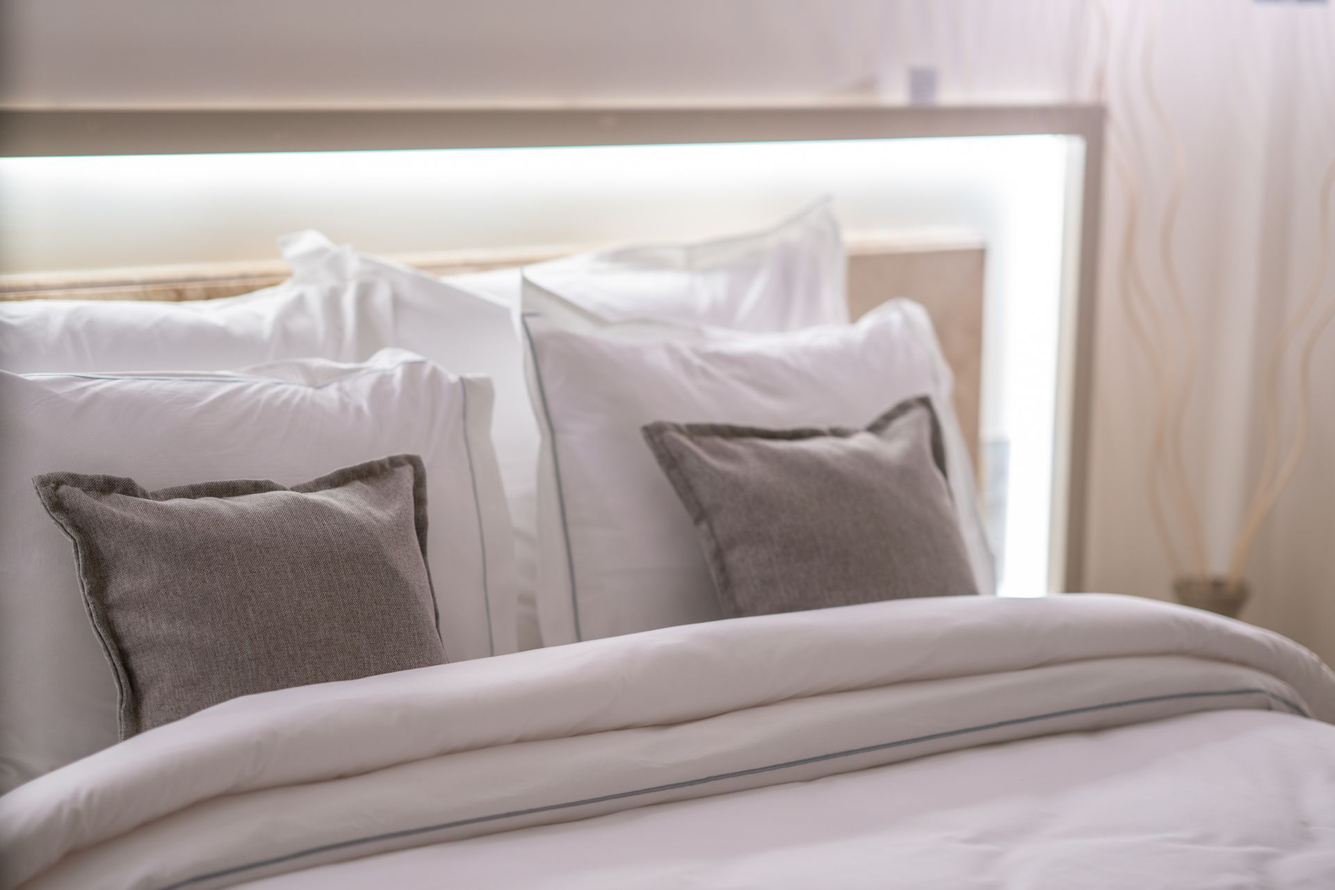  Elemanta Boutique Hotel | White bed with pillows and beige blanket in a softly lit bedroom.