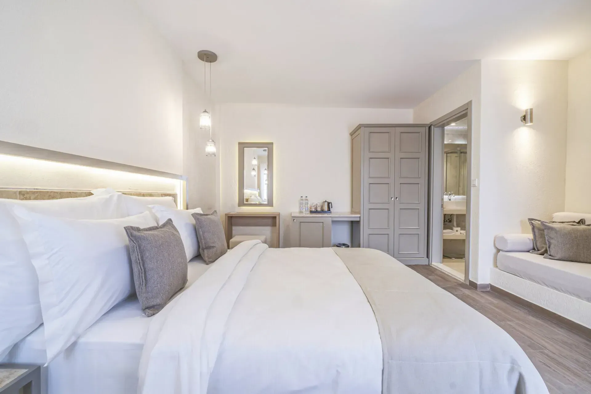  Elemanta Boutique Hotel | Bright modern bedroom with a large bed, gray accents, and a window seat by the wall