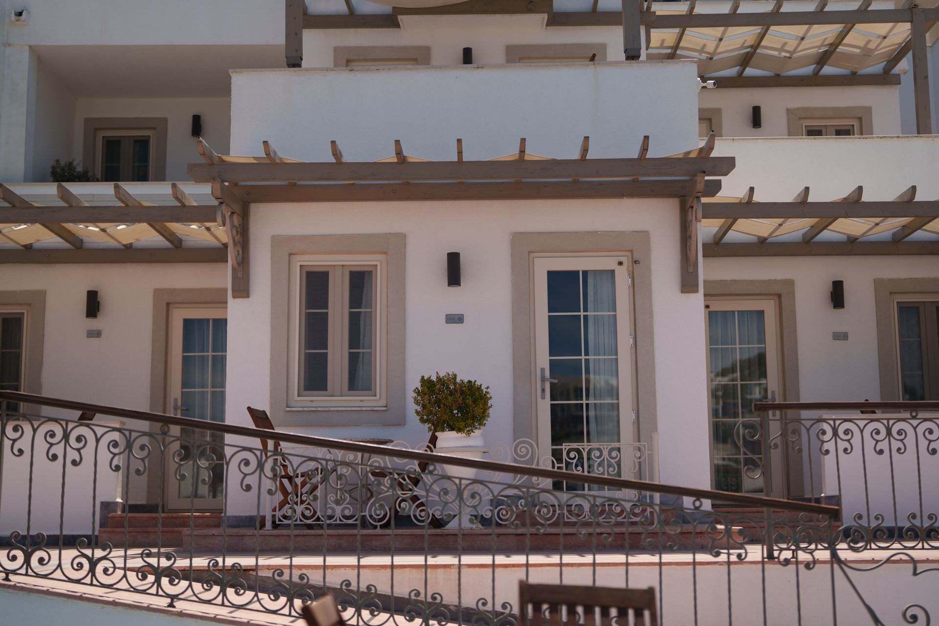 Elemanta Boutique Hotel | White stucco apartment balcony with ornate metal railing,