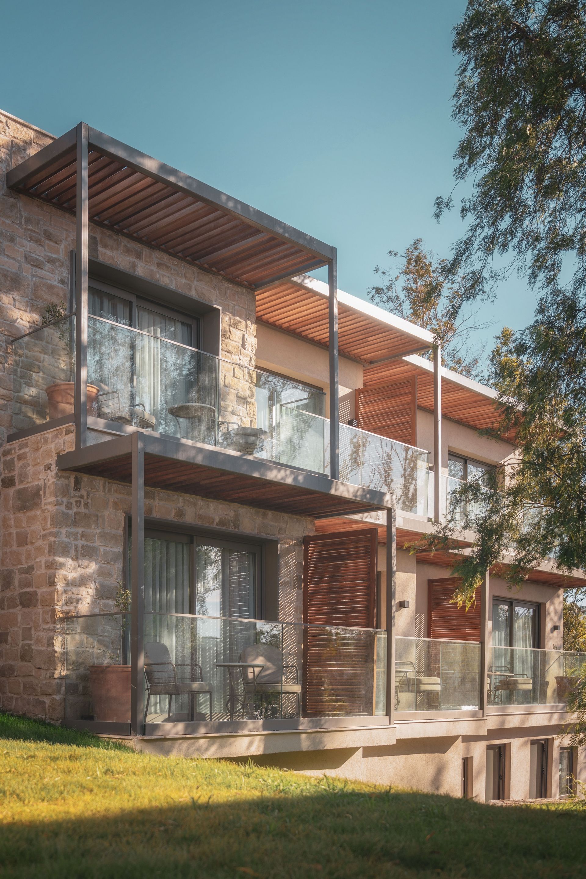Elemanta Boutique Hotel | Modern two-story brick and wood apartment building with balconies