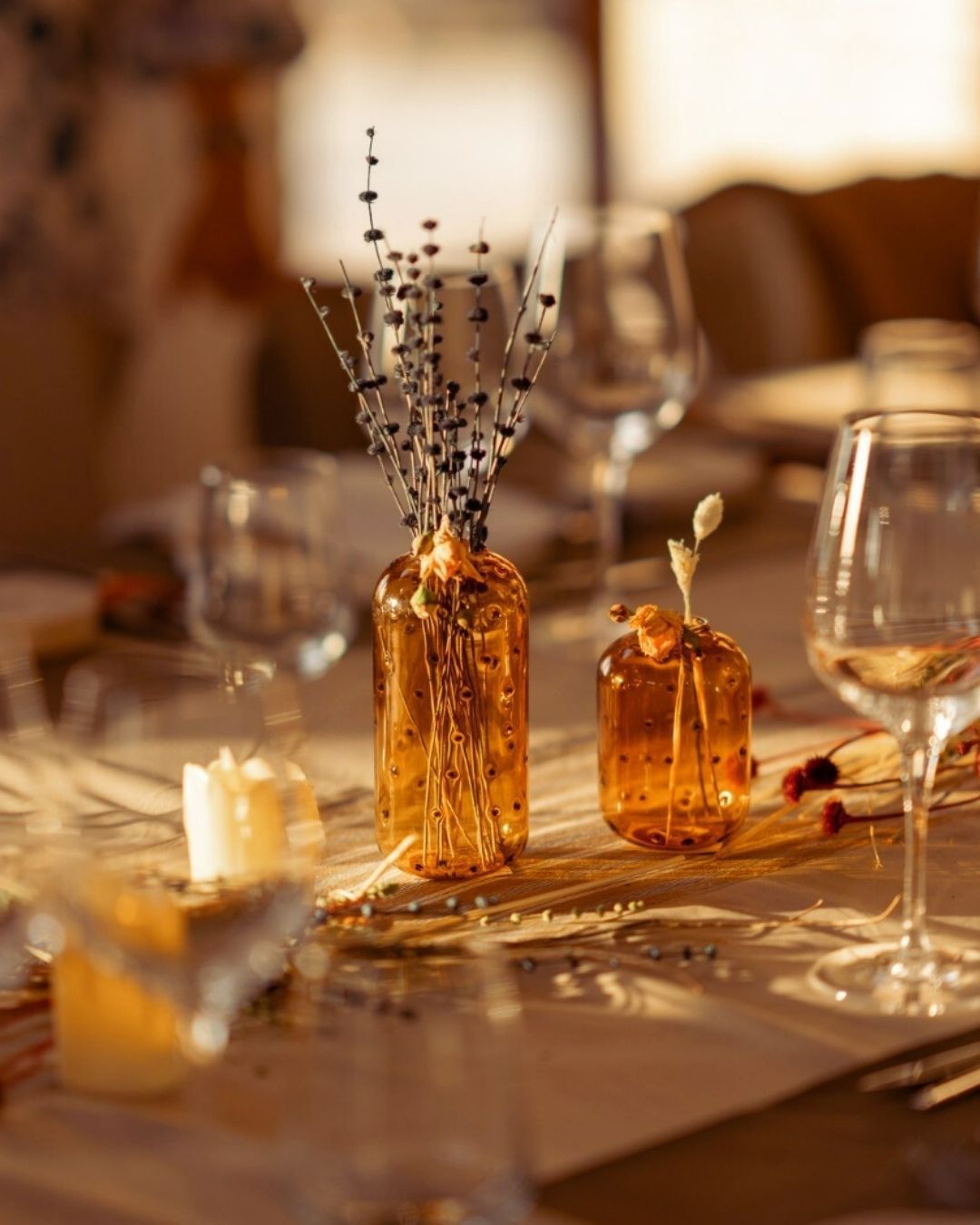 Elemanta Boutique Hotel | Amber glass vases and candles on a warmly lit table with wine glasses and tableware