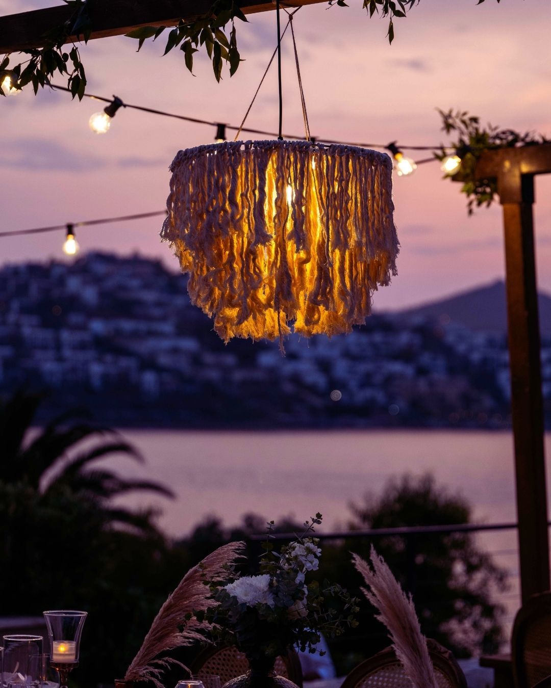 Elemanta Boutique Hotel | Twilight lakeside terrace with glowing chandelier, string lights,