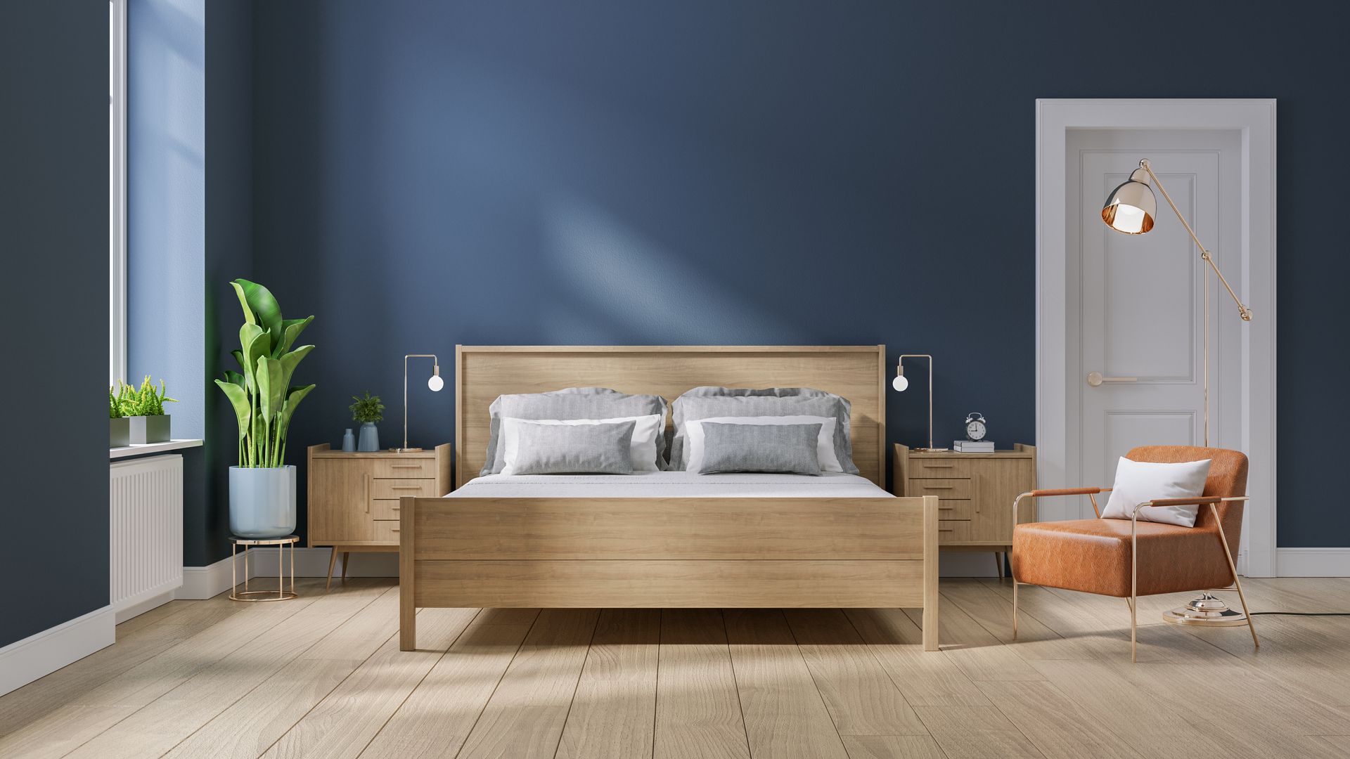 Bedroom with light wood flooring, bed with white and blue pillows, desk, and white bedside table.
