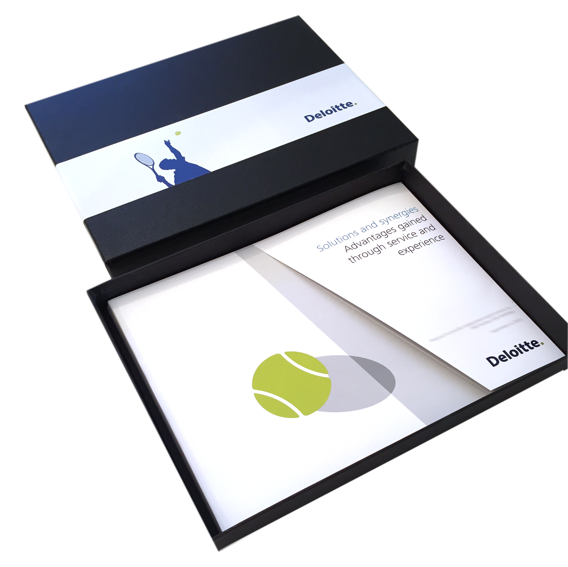 Open black presentation box with a white card, booklet, and green tennis ball graphic inside
