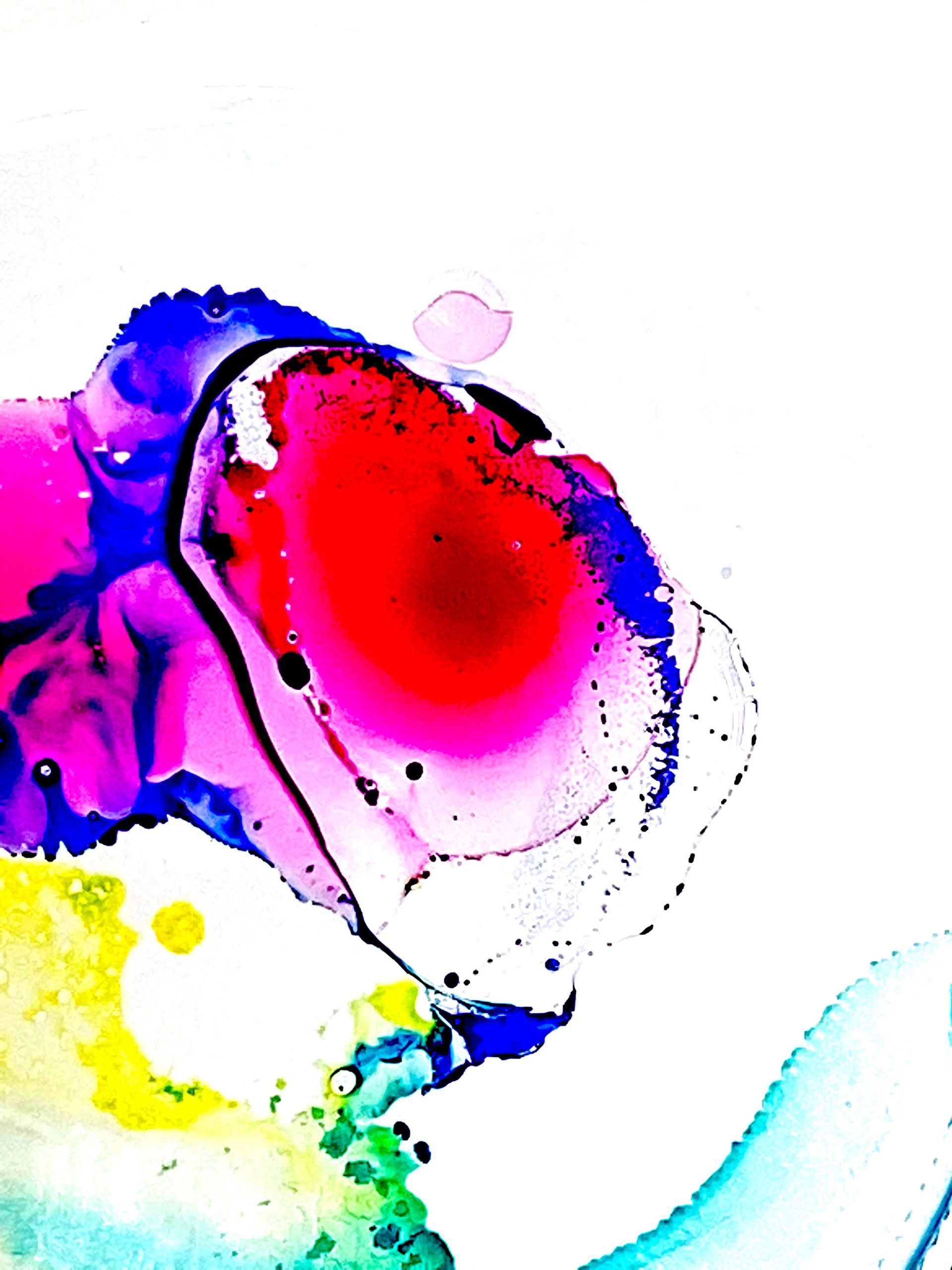 Abstract watercolor-style splash in red, pink, blue, yellow, and black on a white background