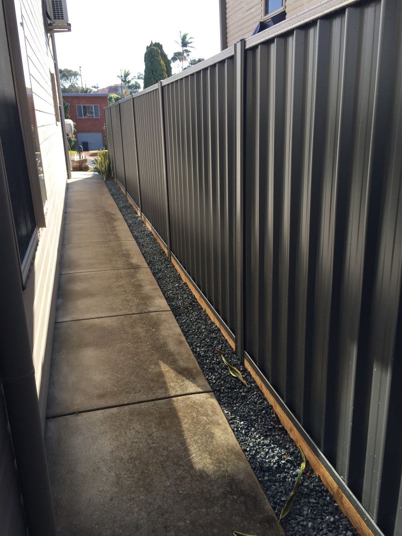 A Fence Along a Sidewalk Next to a House — Aztech Fencing In Port Macquarie, NSW