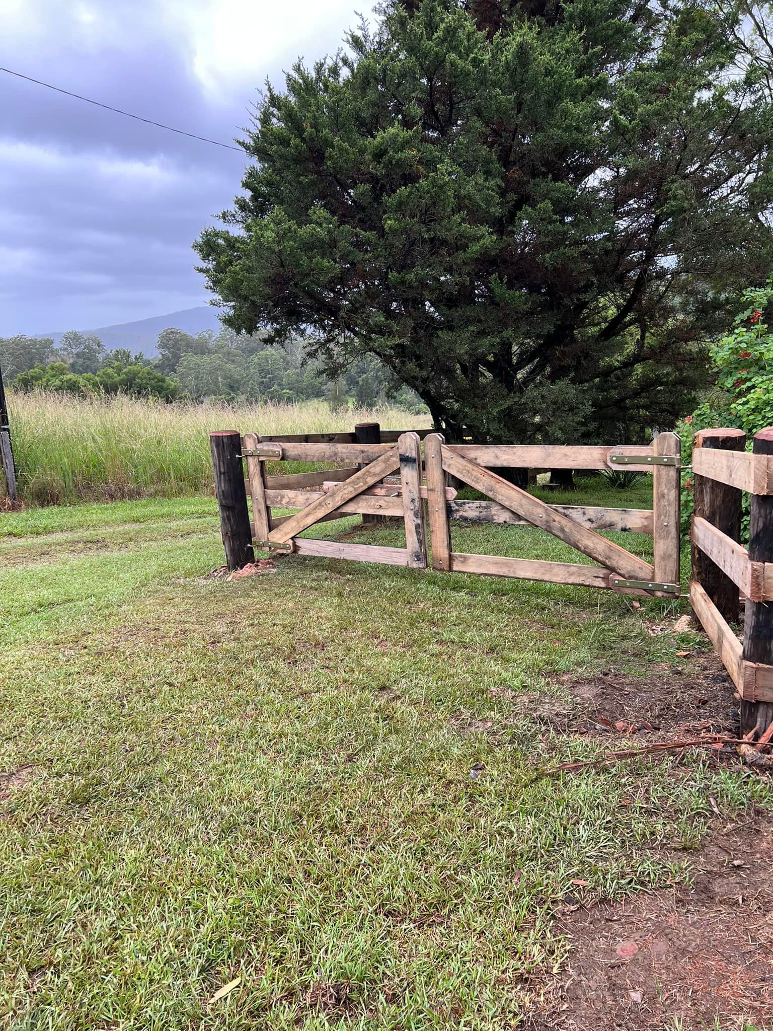 A House With a Wooden Fence Around It — Aztech Fencing In Lake Cathie, NSW