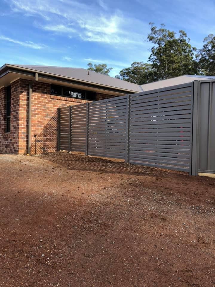 A Brick House With a Fence in Front of It — Aztech Fencing In North Haven, NSW