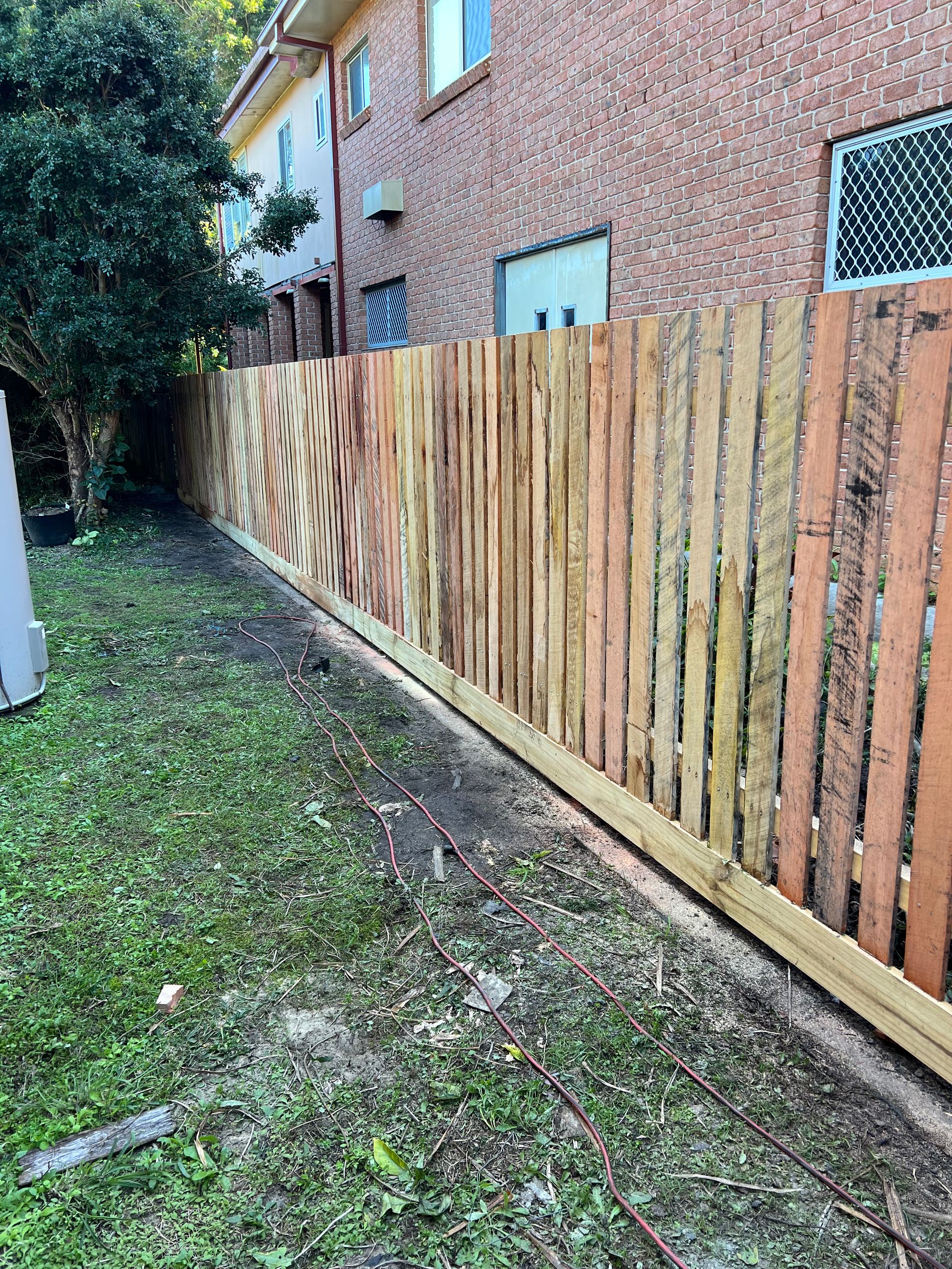 A White Truck is Parked in a Yard Next to a Wooden Fence — Aztech Fencing In Wauchope, NSW