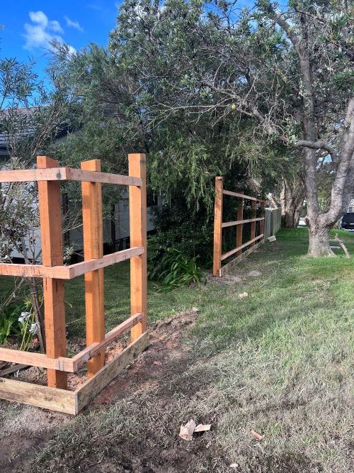A Wooden Fence is Surrounded by Trees in a Yard — Aztech Fencing In Upsalls Creek, NSW