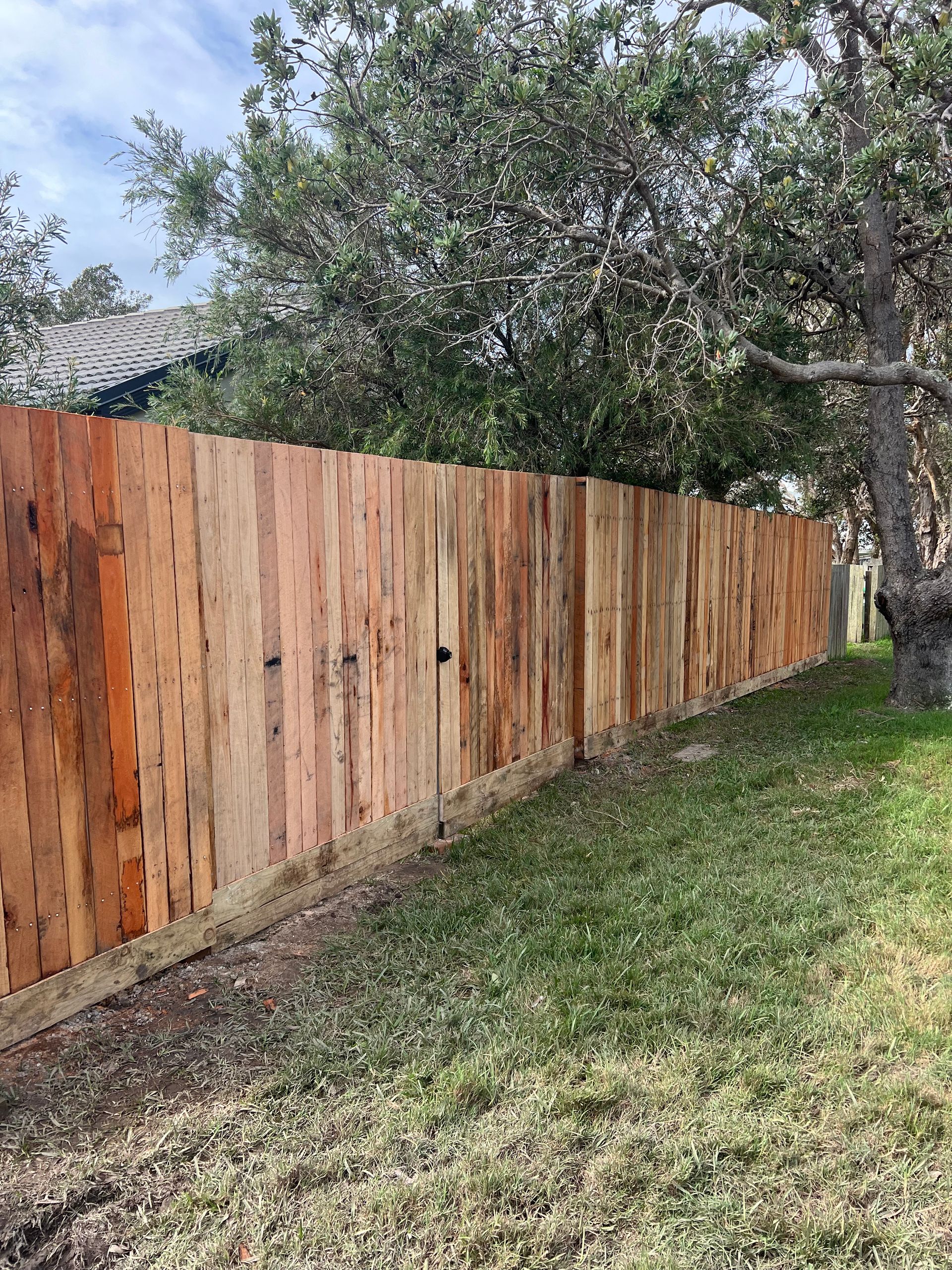 A Wooden Fence is in the Middle of a Lush Green Field — Aztech Fencing In Bonny Hills, NSW