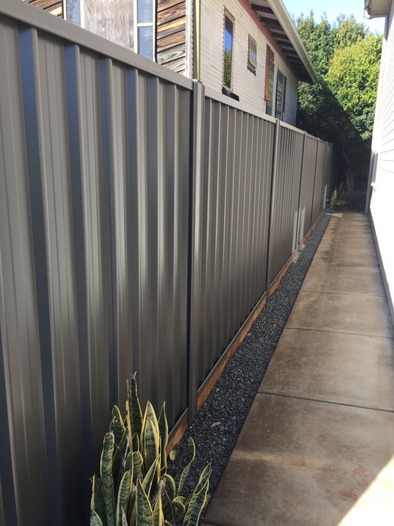 A Fence Along a Sidewalk Next to a House — Aztech Fencing In Lake Cathie, NSW