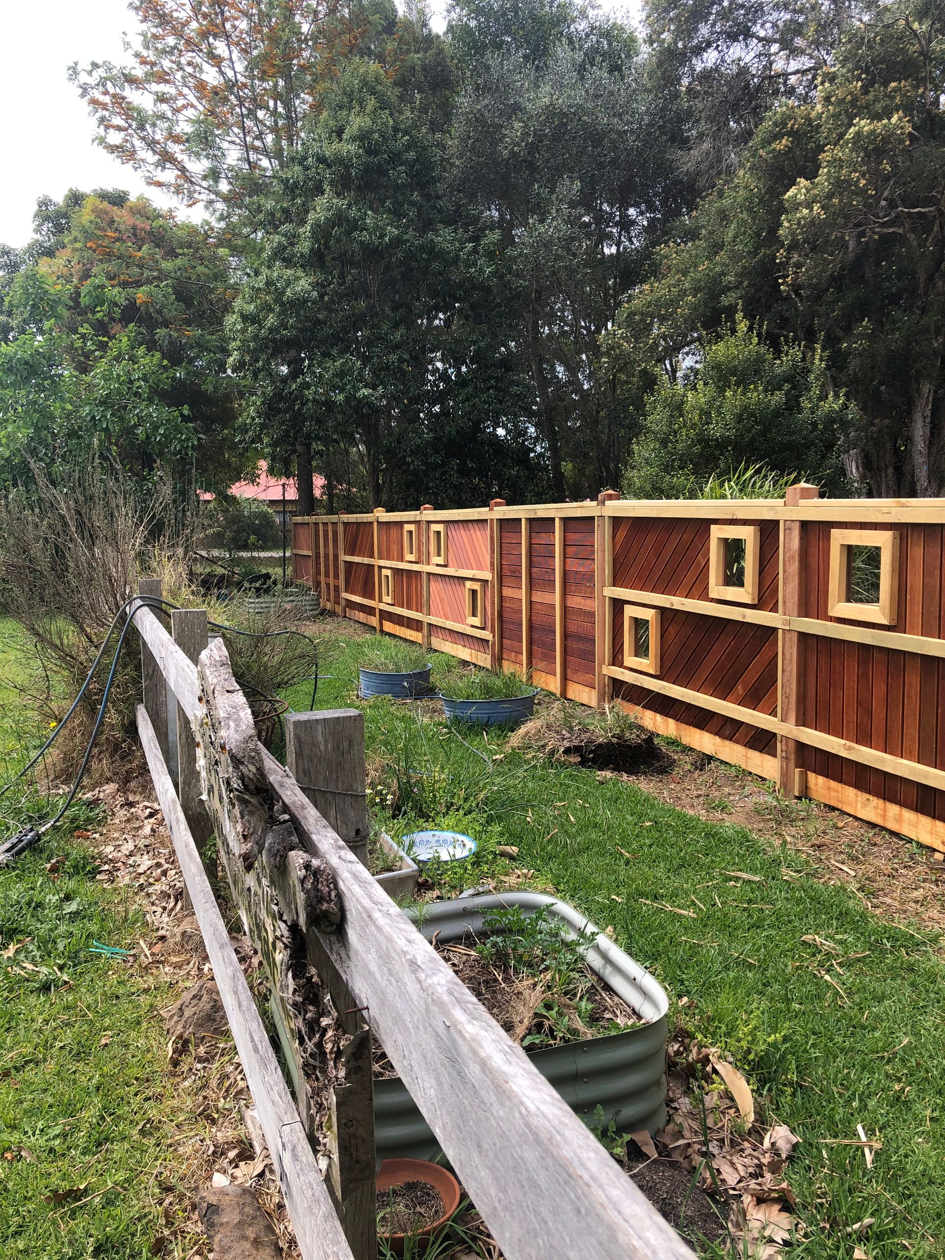 A Backyard With a Wooden Fence and a House — Aztech Fencing In Taree, NSW