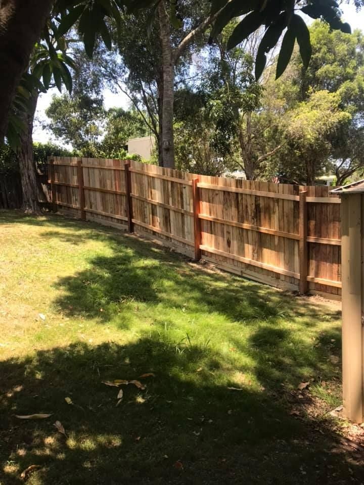 A Wooden Fence Surrounds a Lush Green Yard — Aztech Fencing In Upsalls Creek, NSW