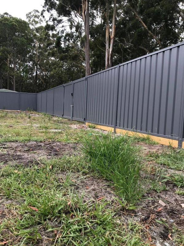 A Fence is Surrounding a Grassy Field With Trees in the Background — Aztech Fencing In Upsalls Creek, NSW