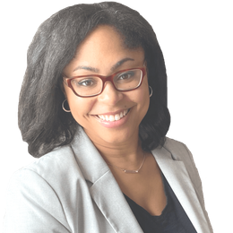 A smiling person with dark hair and glasses wears a light gray blazer over a black top against a white background.