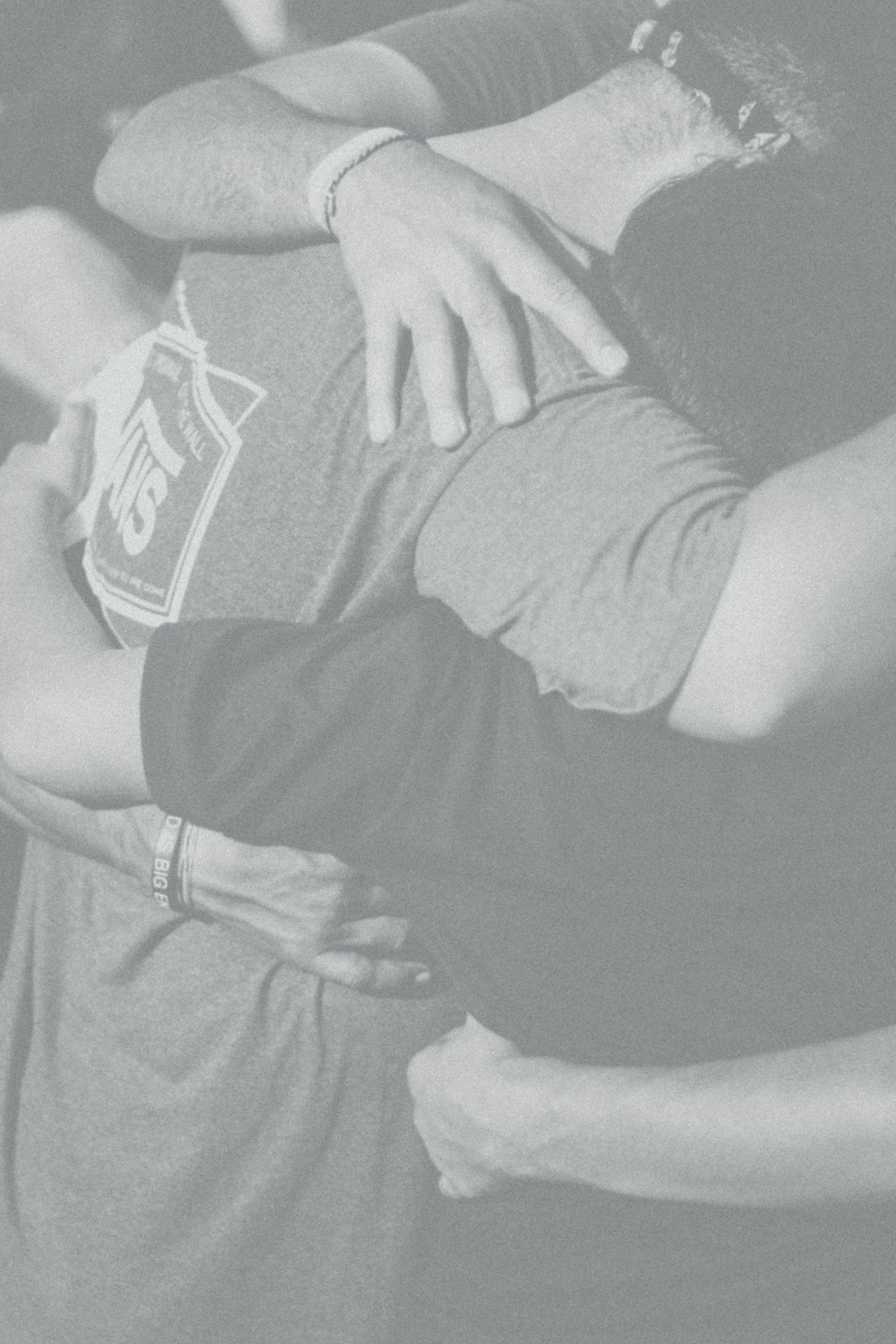 A group of people are hugging each other in a black and white photo.