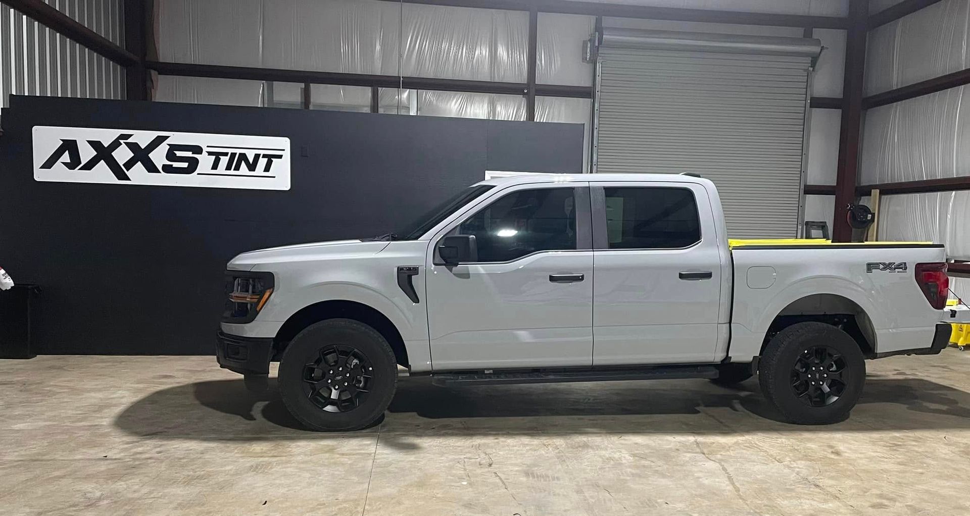 A white pickup truck is parked in a garage.