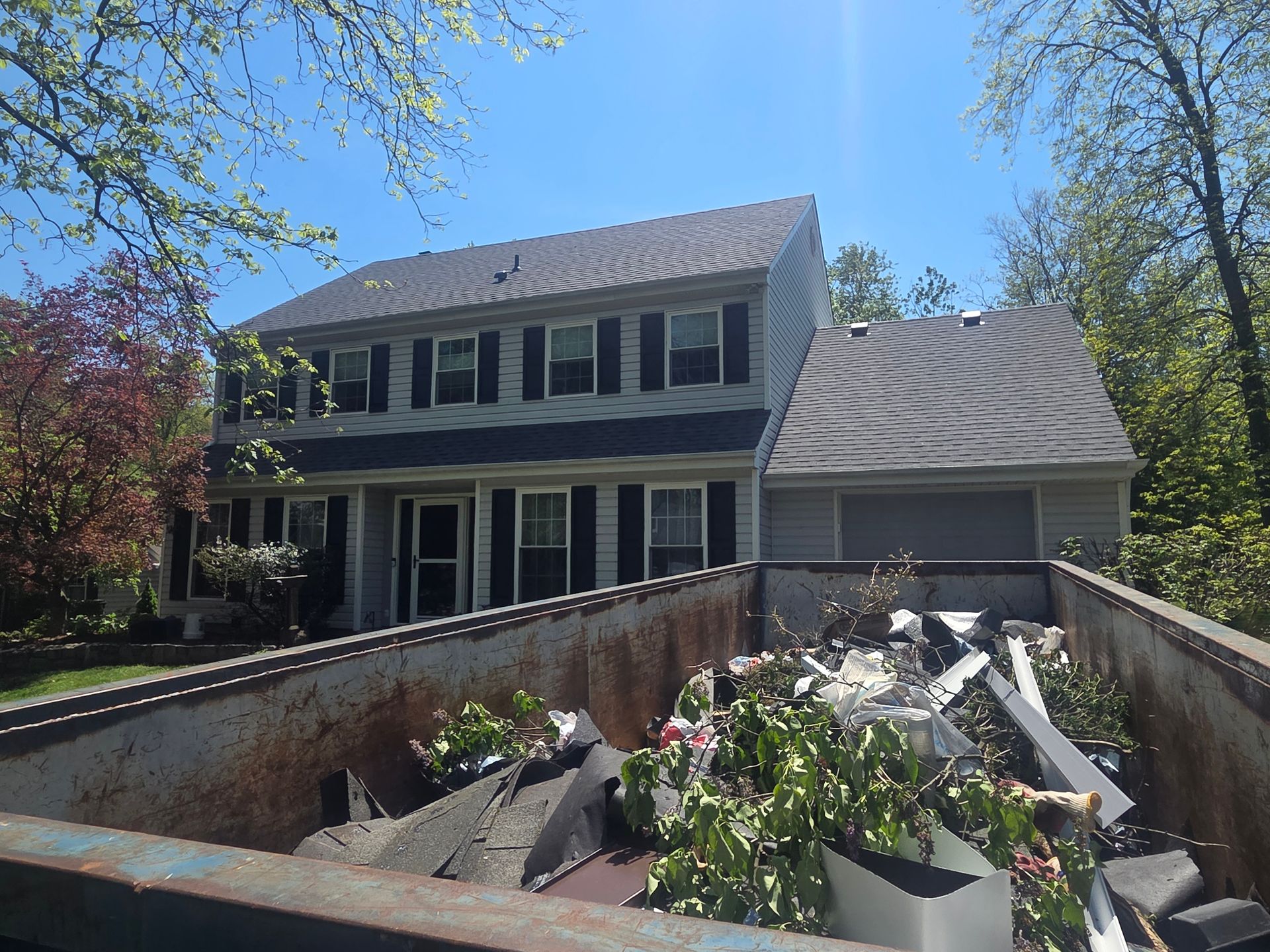 House with front ramp lined with debris and broken materials under a blue sky
