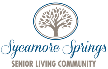 The sycamore springs senior living community logo has a tree in a circle.