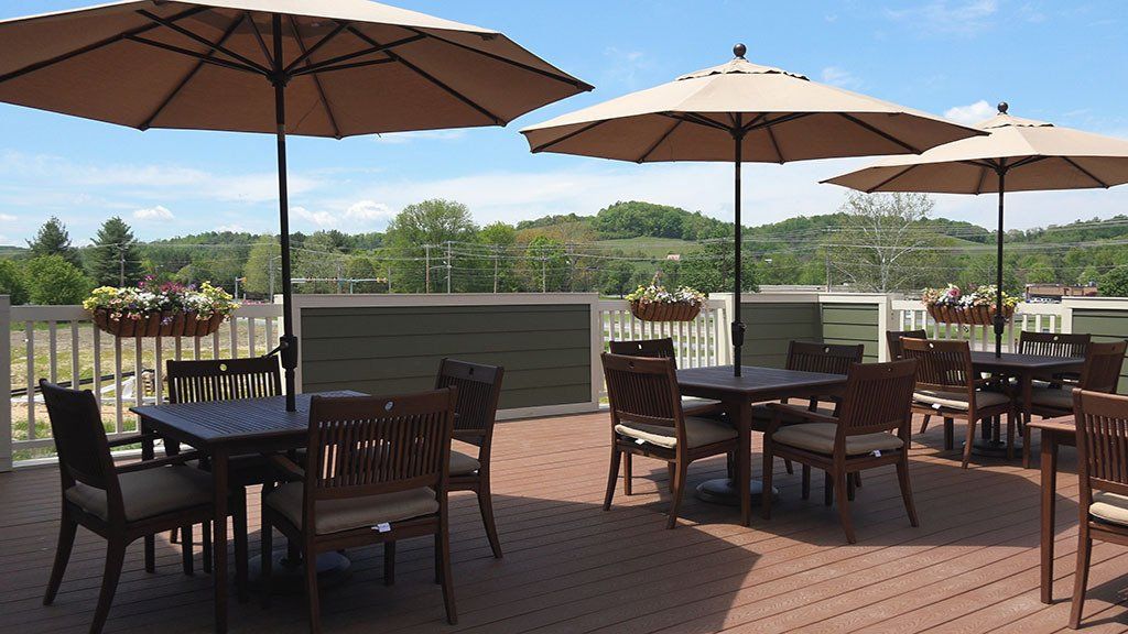 A patio with tables and chairs and umbrellas on a sunny day
