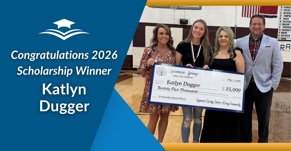 Congratulations 2026 scholarship winner Katlyn Dugger standing with a large check in a gymnasium
