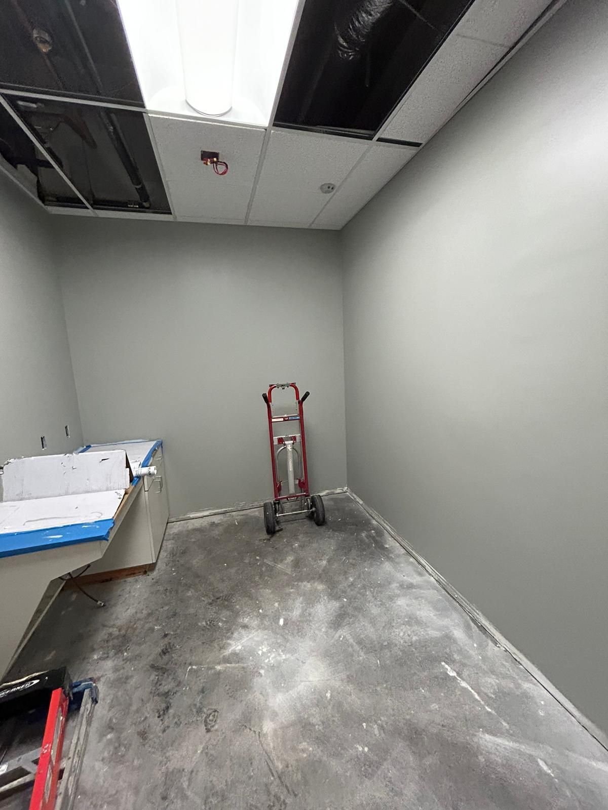 An empty room with a dolly in the middle of it.