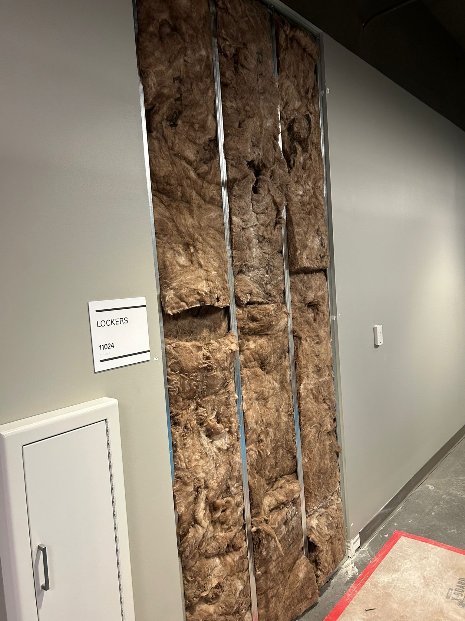 A wall with a lot of rocks on it in a hallway.