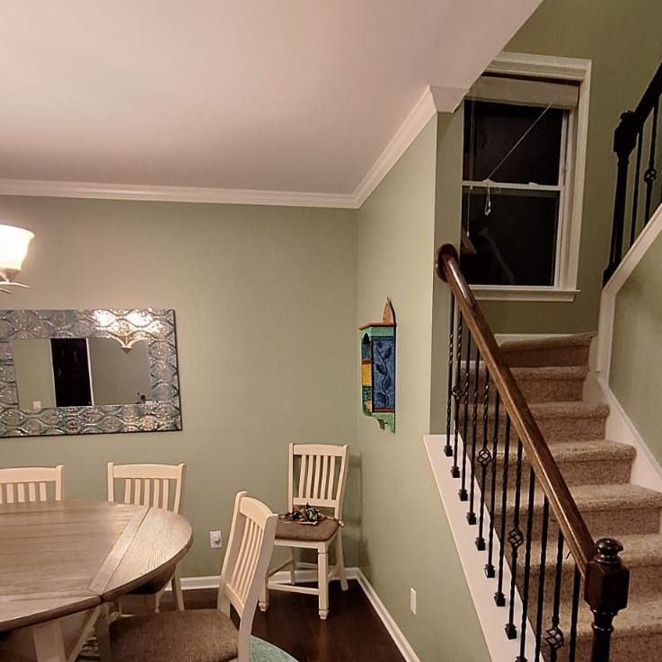 A dining room with a table and chairs and stairs