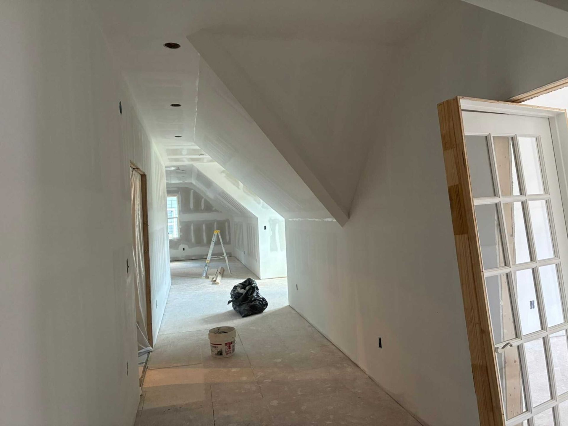 A set of wooden stairs leading up to a white wall.