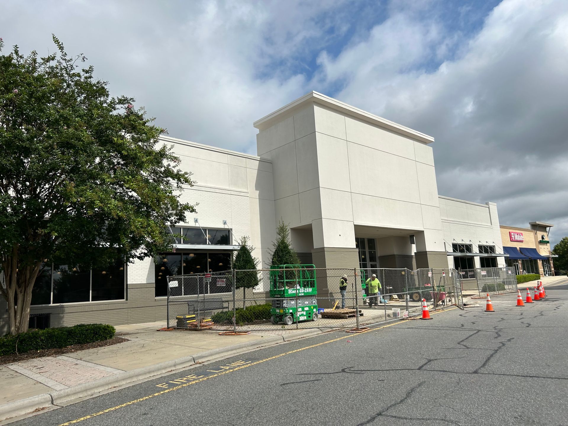 A large white building is being built on the side of the road.