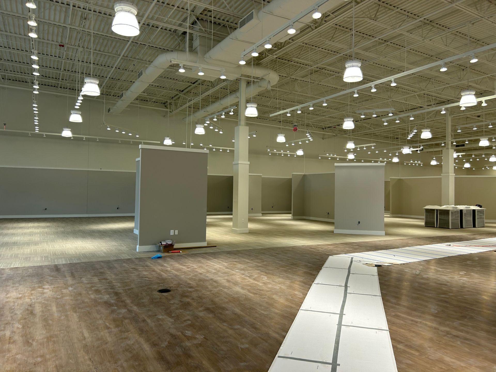 A large empty room with a lot of lights on the ceiling