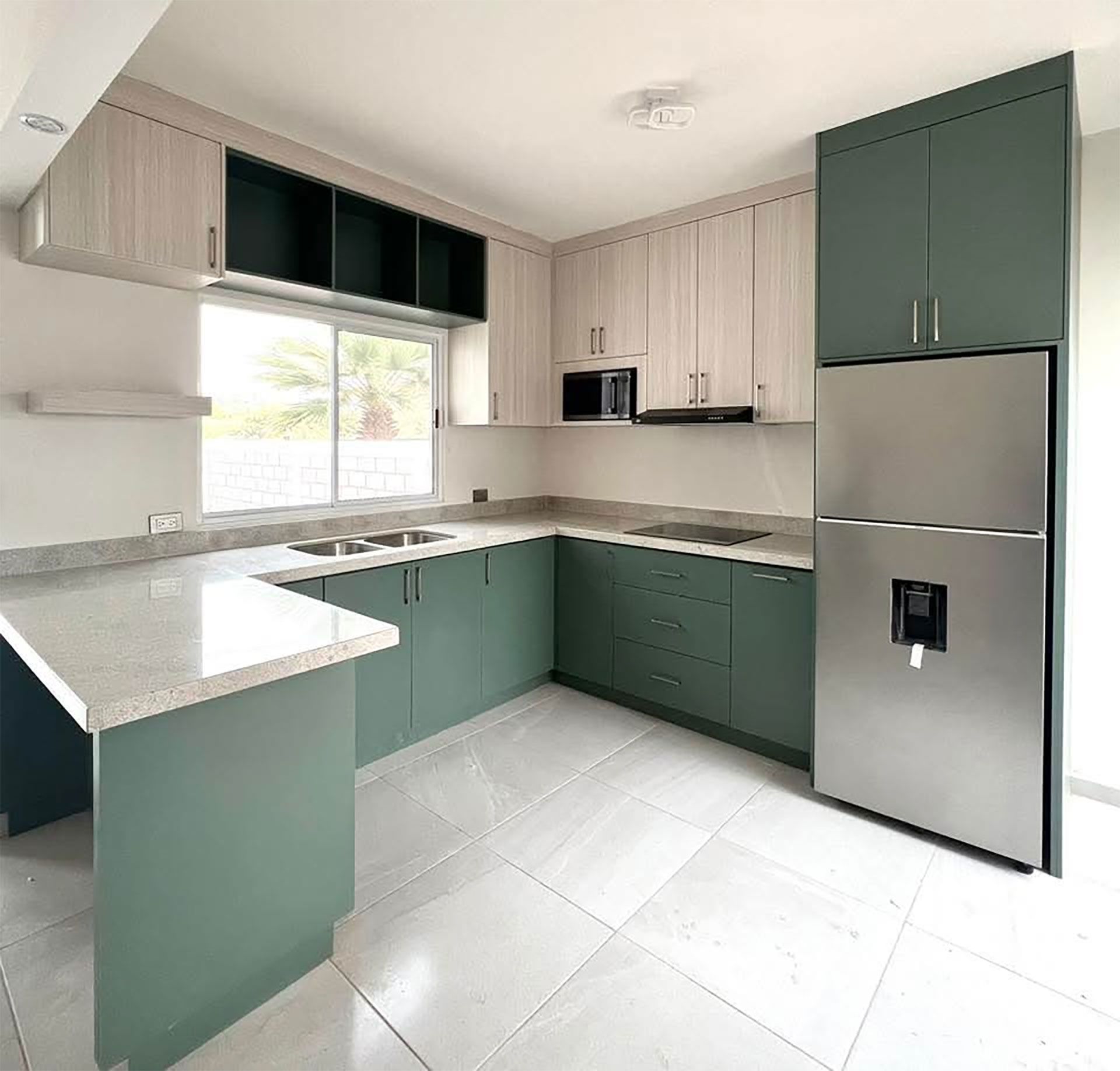 Cocina integral con gabinetes verdes y alacenas de madera