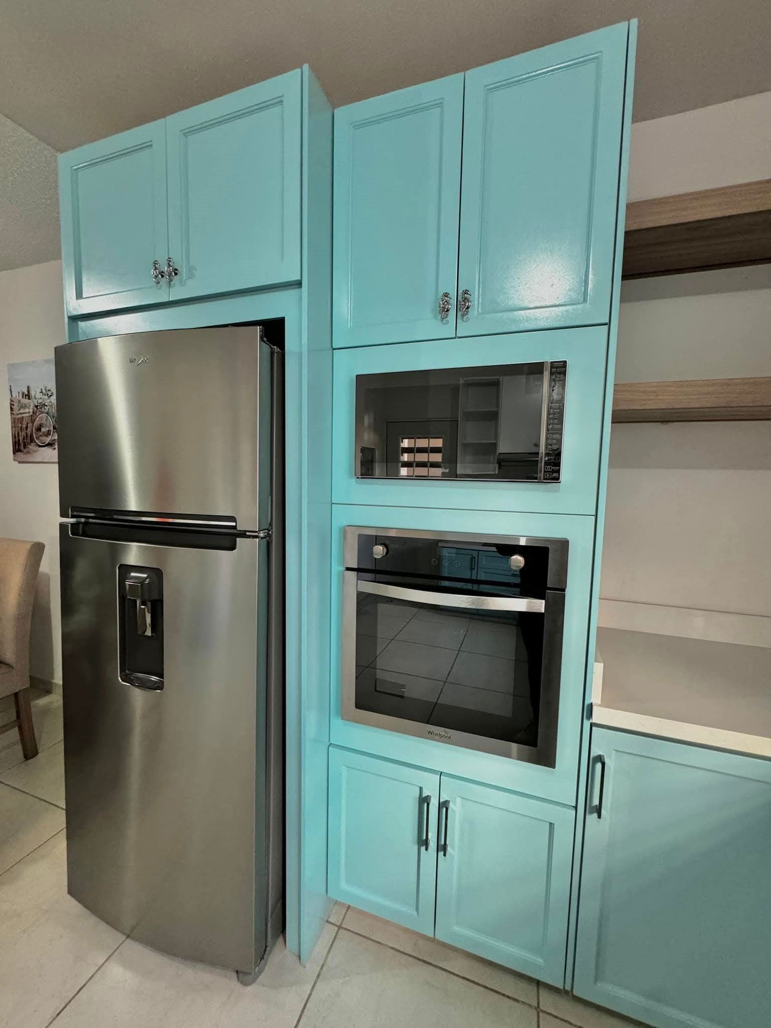 Cocina integral color aqua con torre de hornos