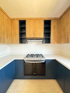 Cocina integral con alacenas de madera y gabinetes azules